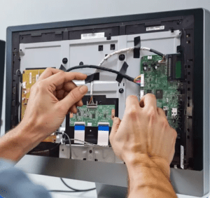 Technician repairing a TV's internal components.