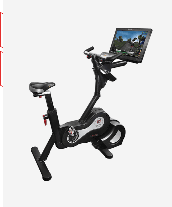 A laptop computer is on the desk of this exercise bike.