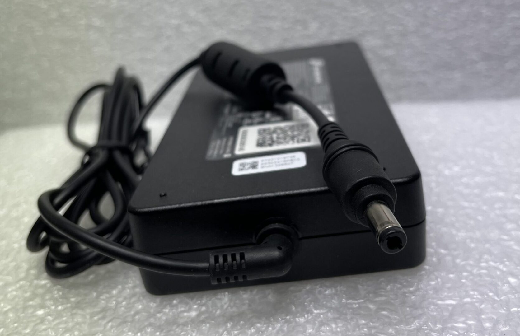 Black laptop power adapter with attached cable.